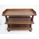 A mid Victorian mahogany three tier serving buffet with gallery and shaped end supports on bun feet