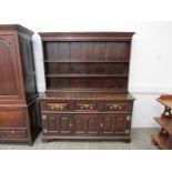 An 18th century oak dresser with a boarded plate rack and dentil moulded cornice,