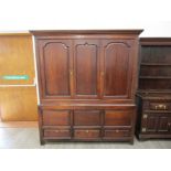 A George III joined oak press cupboard-on-chest, the central fielded panel,