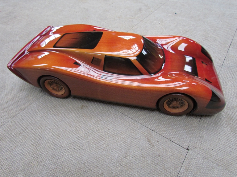 A carved wooden sports car by Woodley Productions,