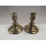 A pair of silver candlesticks with weighted bases,