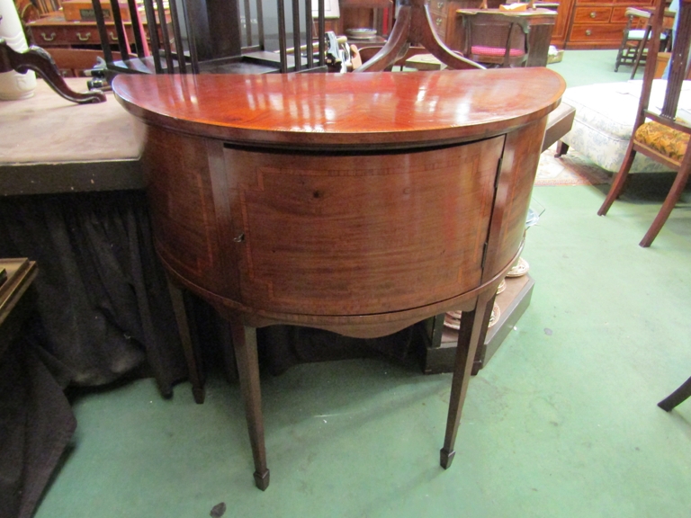 An Edwardian cross banded mahogany bow front sideboard the single door with working key over spade