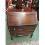 An Edwardian mahogany bureau with fall front revealing compartmental interior over three drawers,