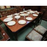 An Arts & Crafts oak extending dining table with two extra leaves and winding handle together with