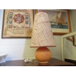 An orange coloured ceramic table lamp with shade