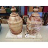 A pair of 19th Century alabaster lidded urns with square marble stands,