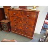 A Victorian mahogany and walnut front veneered two over three chest of drawers with bun handles