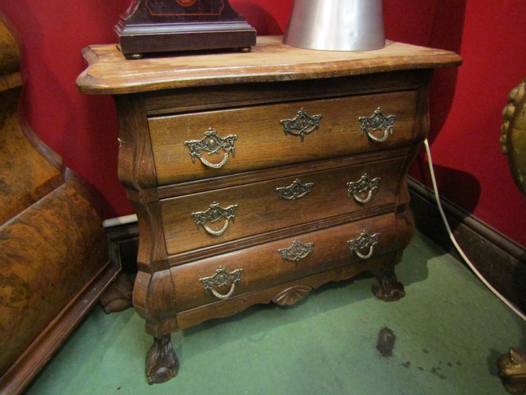 A French style diminutive bombe chest of three drawers on ball and claw feet.