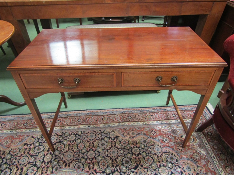 An Edwardian crossbanded mahogany side table the two frieze drawers over square tapering legs,