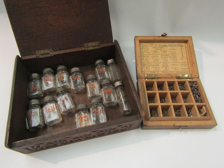 Two wooden boxes of watchmaker's screws, springs etc.