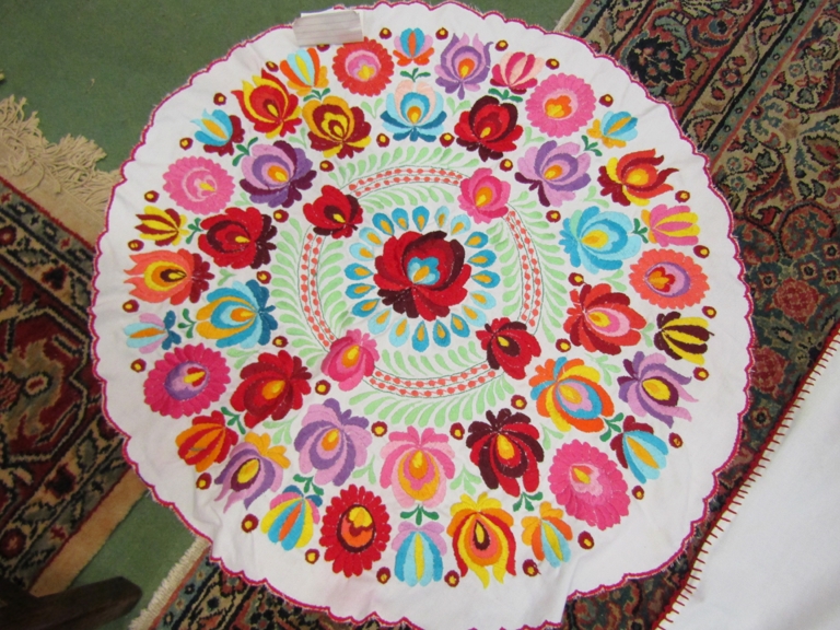 A Hungarian hand embroidered circular tablecloth, 27" diameter, multicoloured,