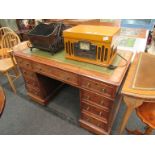 A Victorian mahogany nine drawer kneehole desk with green tooled leather top,