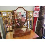 A Victorian flame mahogany shield back table-top mirror on three drawer base,