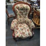A Victorian spoon back open armchair on turned legs