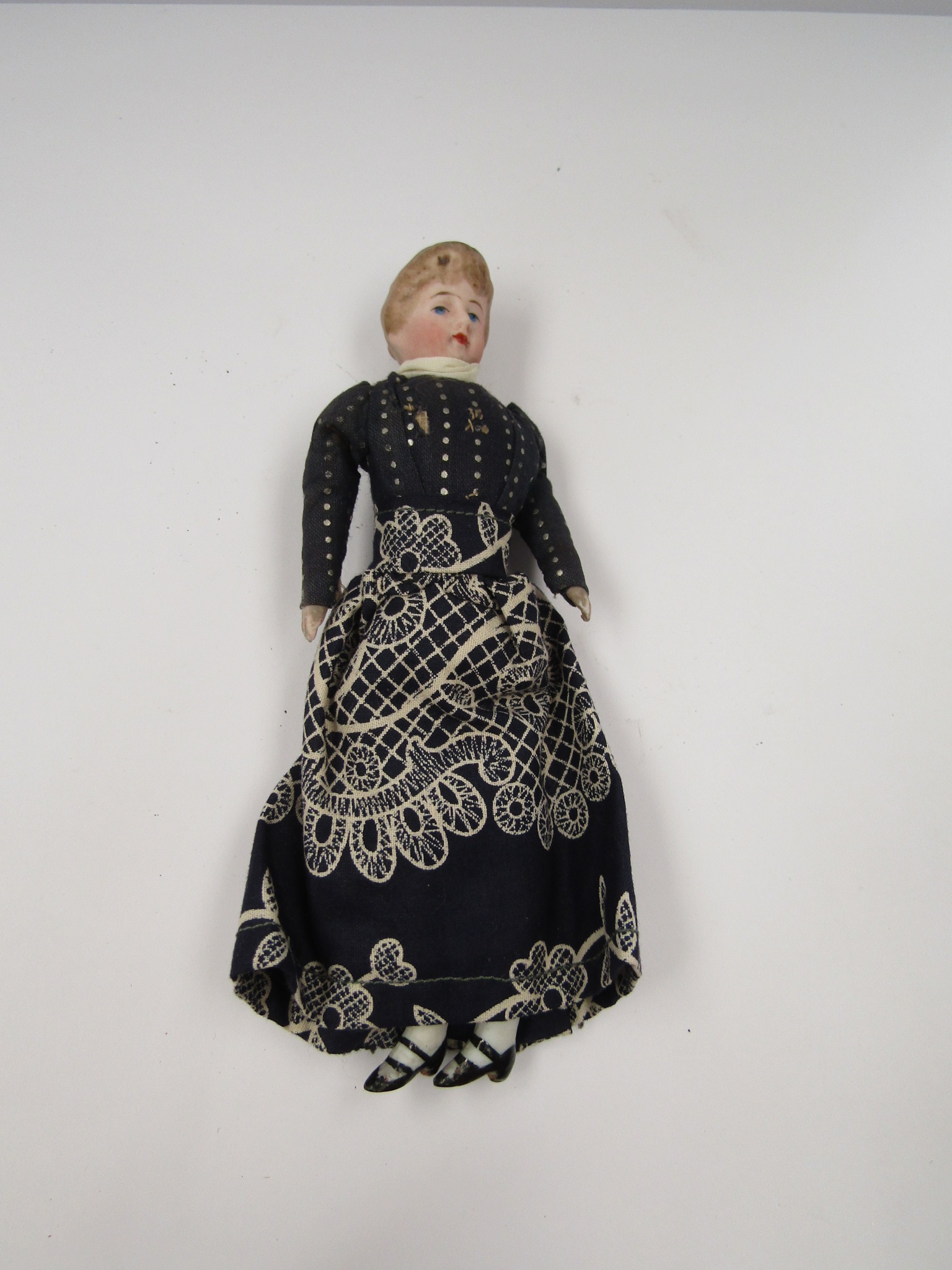 A porcelain doll with associated Hamleys note,