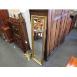 A slim gilt wall mirror,