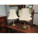 A pair of brass table lamps with shades