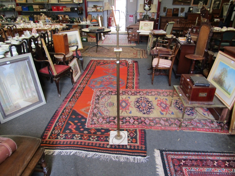 A brass column lamp standard on marble footed base