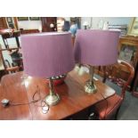 A pair of brass column table lamps with shades