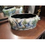 A glazed terracotta planter with blue bird design,