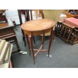 A crossbanded oval top side table on cross stretcher base