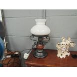 A table lamp as an oil lamp with white glass shade