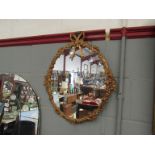 A gilt framed oval mirror with ribbon and swag frame,