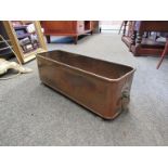 A copper planter with paw feet and lion head handles