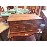 A yew wood seven drawer table top cabinet