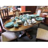 A modern oak D-end extending dining table and four chairs with upholstered seats and backs,