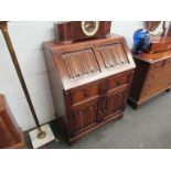 An old charm style oak bureau with linen fold detail,