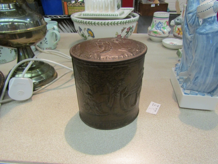 A vintage biscuit tin with embossed Oriental design