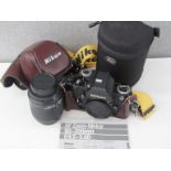 A Nikon F2 SLR camera in black with Nikon AF Nikkor 80-200mm lens and Nikon case