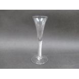 An 18th Century cloudy clear glass wine flute with air twist stem and domed foot with pontil mark.