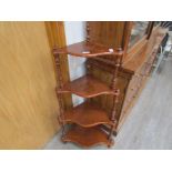 A Victorian walnut corner whatnot with four wavy shelves joined by spiral turned supports.