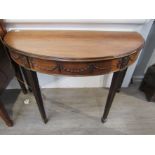 A Georgian mahogany D-end dining table in three sections with swag frieze,