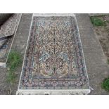 A modern hand made rug, central field decorated with Art Nouveau vase flanked by sprawling trees,