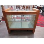 A modern bespoke walnut finish display cabinet with sliding doors, shelved interior.