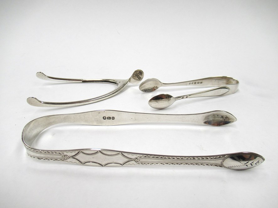 Two pairs of silver sugar tongs including Georgian bright-cut design together with a stirrup