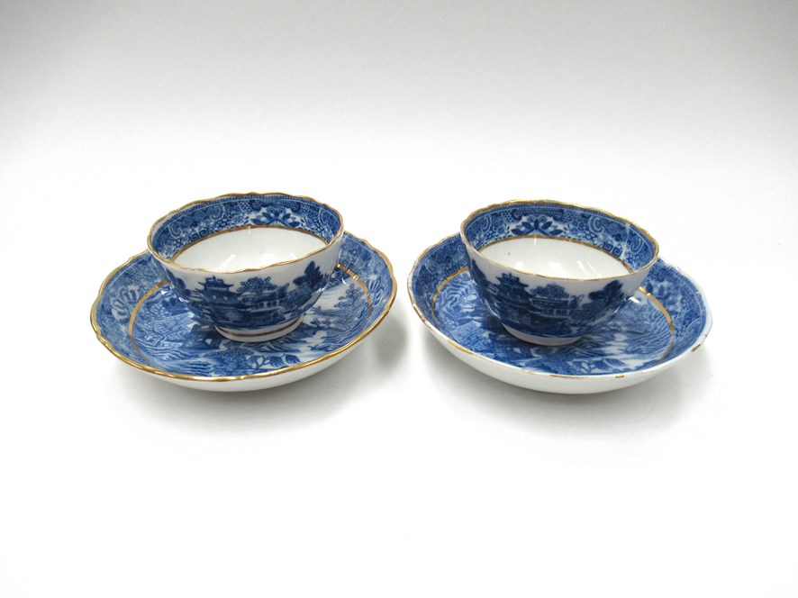 A pair of Caughley blue and white tea bowls, Willow pattern, small chips and cracks to bowl.