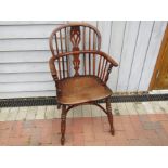 A 19th Century elm seated Windsor armchair with turned front spindles, crinoline stretcher.