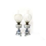 A pair of Victorian blue and white oil lamps with glass globe shades,