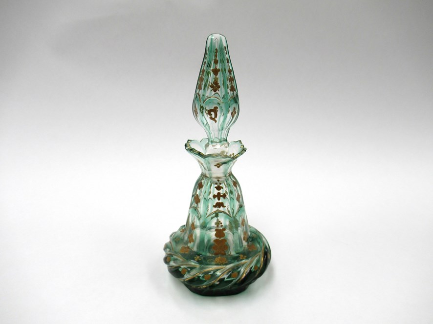 A Victorian cut green overlay clear glass scent bottle of panelled conical form with cushioned base