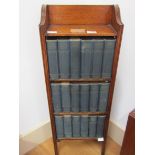 An oak floor standing bookcase with 24 volumes of "Charles Dickens Library"