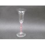 An 18th Century wine glass with bell shaped bowl on a knopped opaque white and red spiral twist