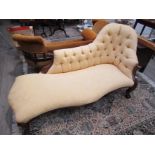 An early Victorian walnut chaise longue with lemon coloured button upholstery,