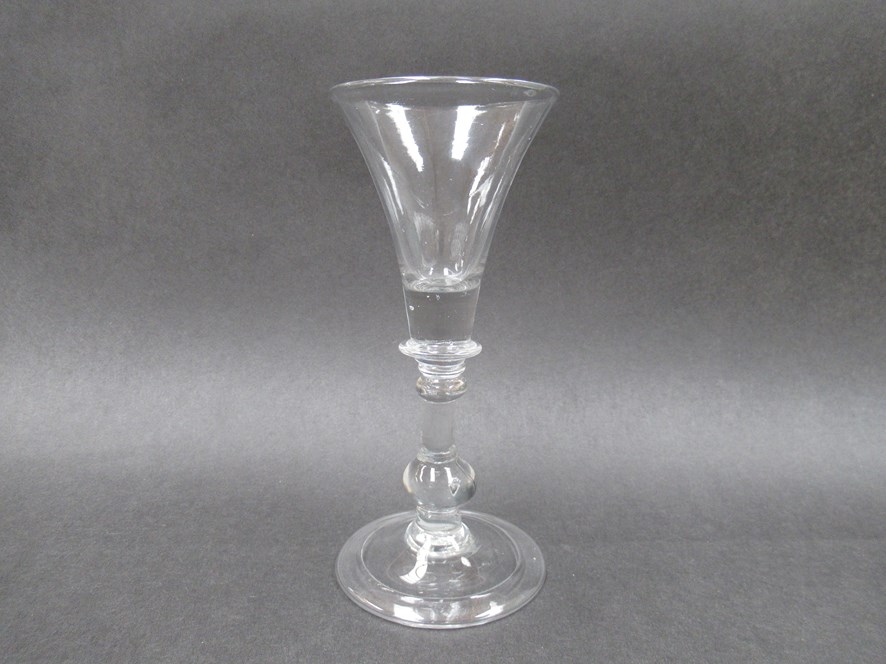 An early 18th Century wine glass with trumpet shaped bowl, solid at the base,