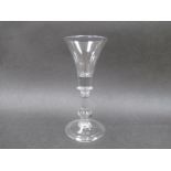 An early 18th Century wine glass with trumpet shaped bowl, solid at the base,