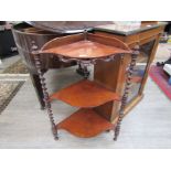 A Victorian mahogany corner whatnot with three shaped shelves joined by barley twist supports