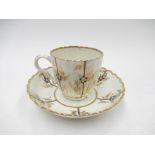 A late 18th Century Caughley teacup and saucer, the fluted body painted with panels of flowers,
